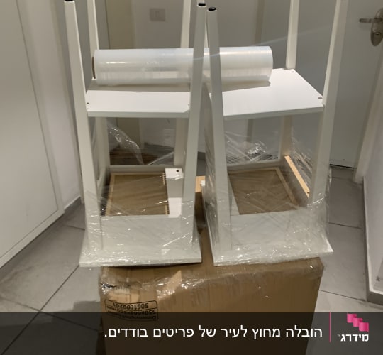 שולחנות הפוכים עטופים בניילון על קרטון